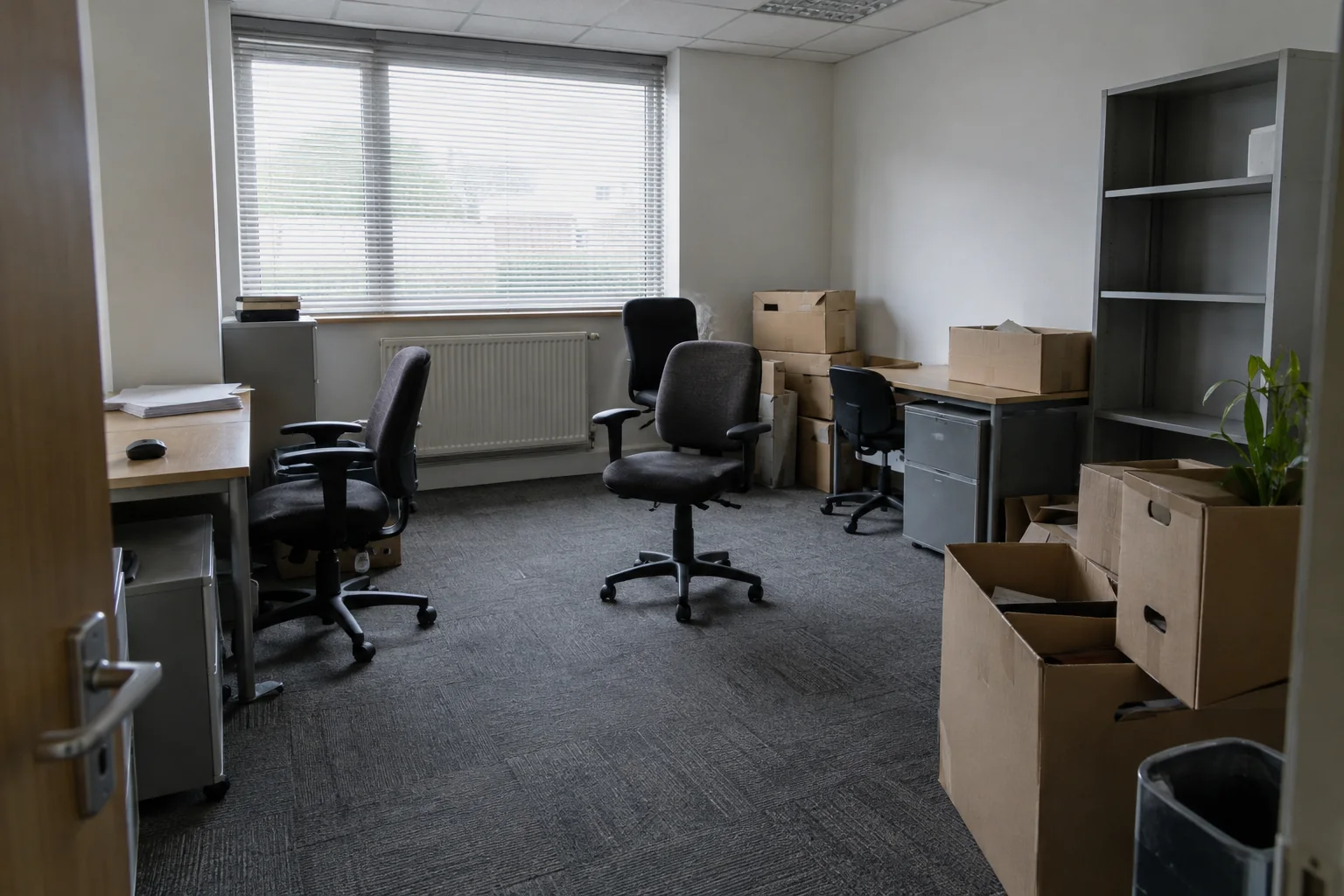 Ordinary office with surplus chairs, desks and boxes